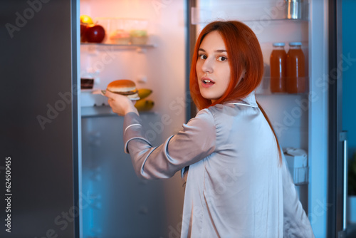 Young woman taking tasty bu...