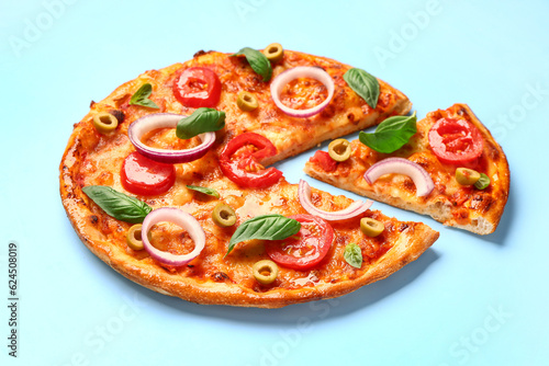 Tasty pizza with olives, tomatoes and basil on blue background