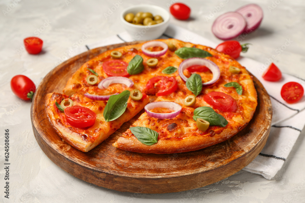 Wooden plate with tasty pizza and ingredients on grunge grey background Wooden plate with tasty pizza and ingredients on grunge grey background
