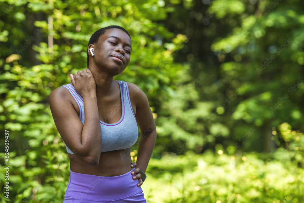 Shot of a sporty young woman holding her neck in pain while exercising outdoors. Shot of a sporty young woman holding her neck in pain while exercising outdoors.