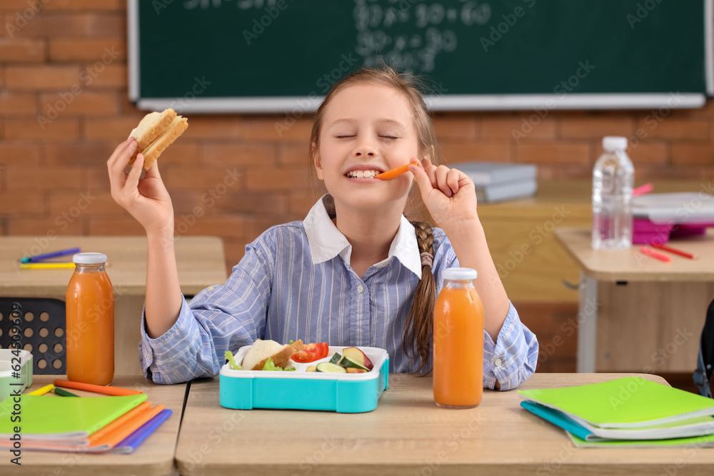 Little girl eating lunch in classroom Stock Photo | Adobe Stock