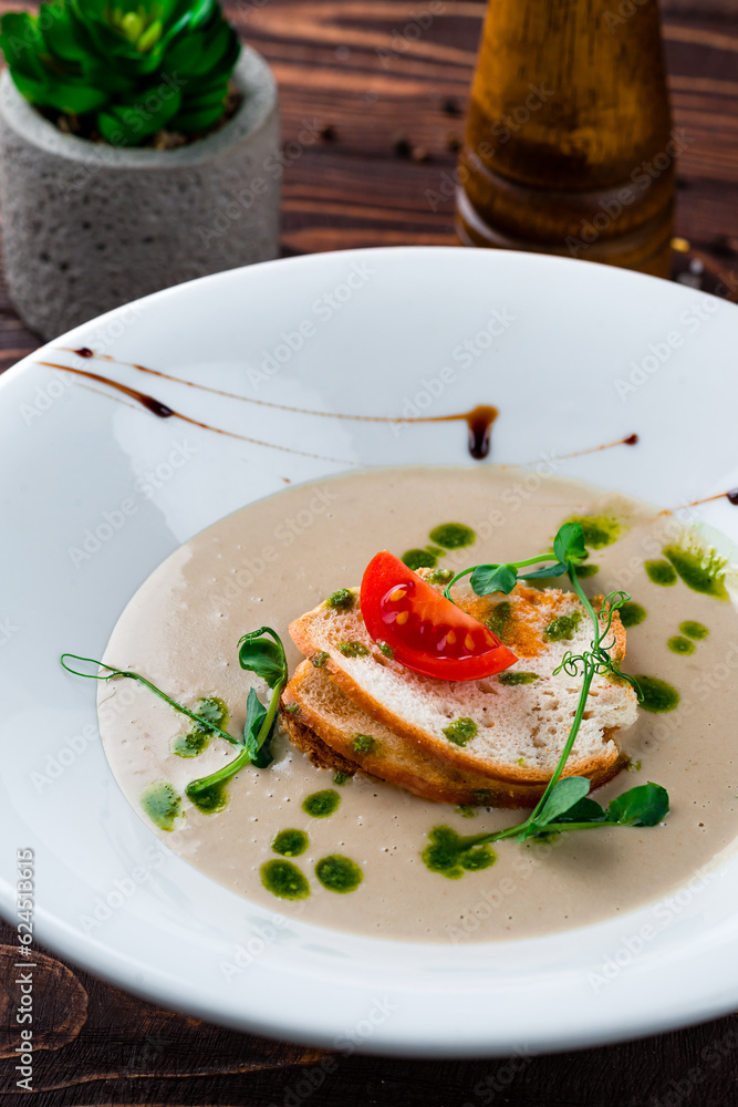 Champignon cream soup with cherry tomatoes, microgreens and croutons, vegetarian food. Champignon cream soup with cherry tomatoes, microgreens and croutons, vegetarian food.