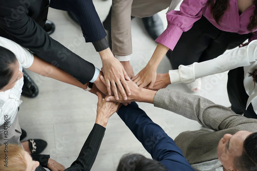 Business team stacking hands as symbol of unity