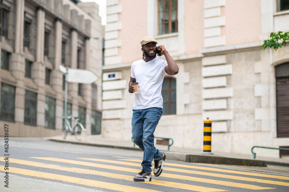 Man in a white tshirt crossing the street Man in a white tshirt crossing the street