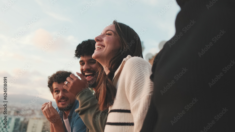 Obraz premium Close-up of young people, guys and girls friends standing hugging each other on the balcony looking at the beautiful views