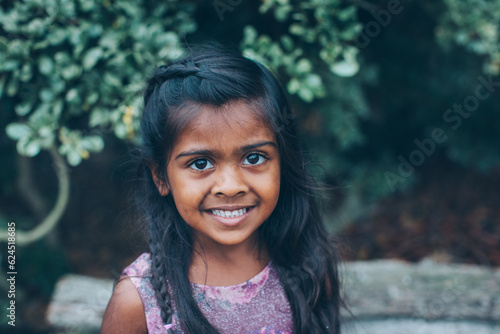 Photography close up beautiful indian little girl in the park with trees and greenery