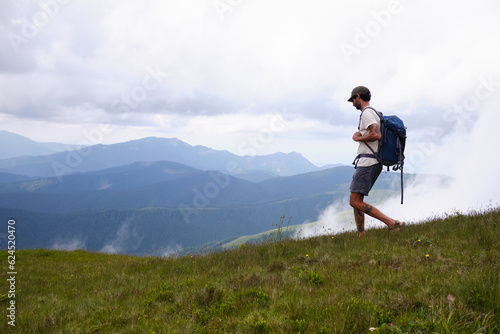 Baiului Mountains trails. Man traveler with backpack is hiking in mountain.Traveling in nature.Rearview shot of a middle aged man hiking in the mountains. Bucegi natural park. 