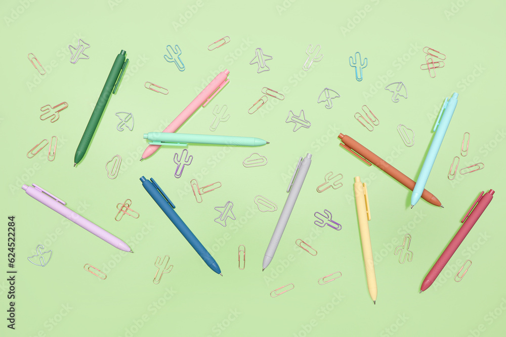 Colorful pencils and paperclips on green background Colorful pencils and paperclips on green background