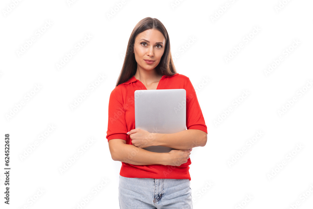 portrait of a successful brunette woman with straight hair in a red t-shirt and jeans with a working laptop. e-business concept portrait of a successful brunette woman with straight hair in a red t-shirt and jeans with a working laptop. e-business concept