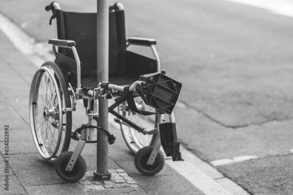 a wheelchair at a streetlight in black and white
