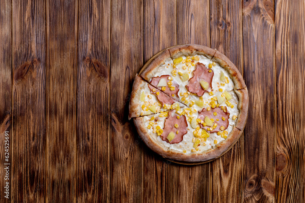 Delicious pizza with ham, pineapple, corn on a creamy base on woden background. Hawaiian pizza Delicious pizza with ham, pineapple, corn on a creamy base on woden background. Hawaiian pizza