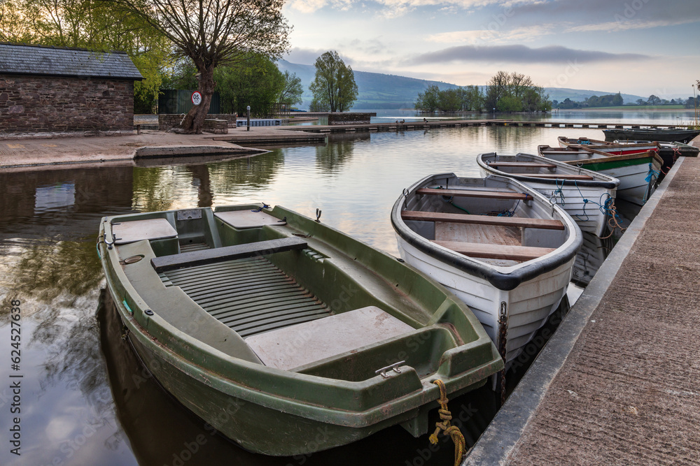 Obraz premium Boats tied to the jetty at Llangorse Lake, Brecon Beacons National Park. Taken just after sunrise. 