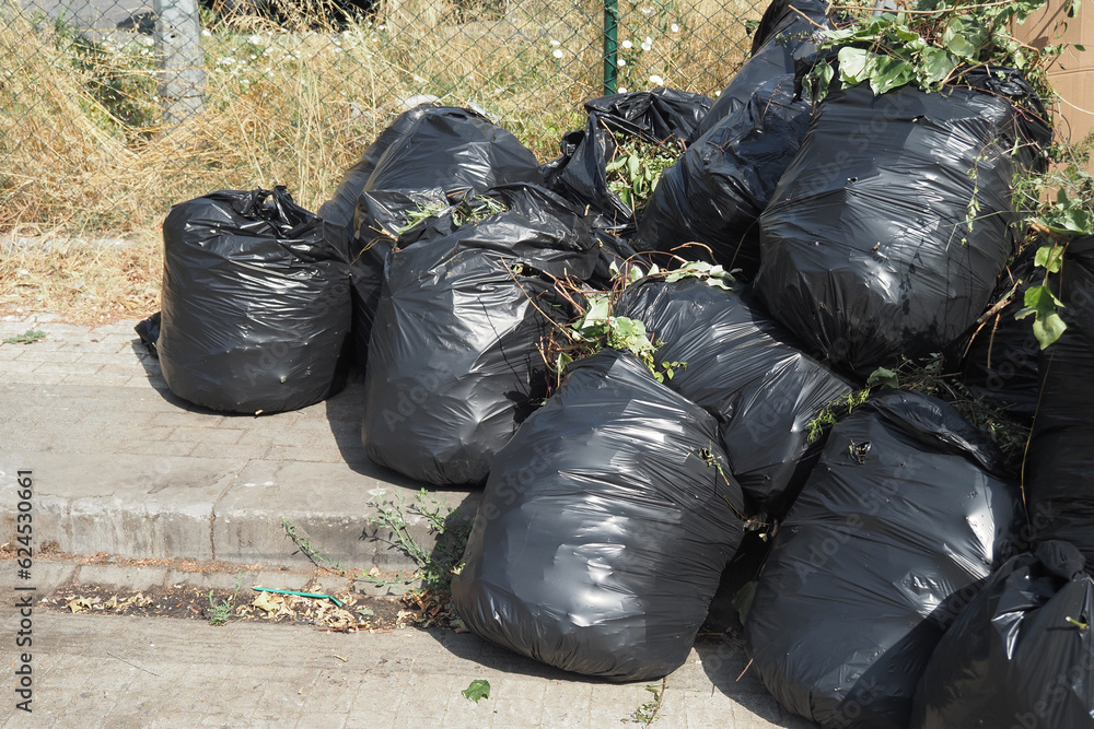 Black garbage bags stack on a park Black garbage bags stack on a park