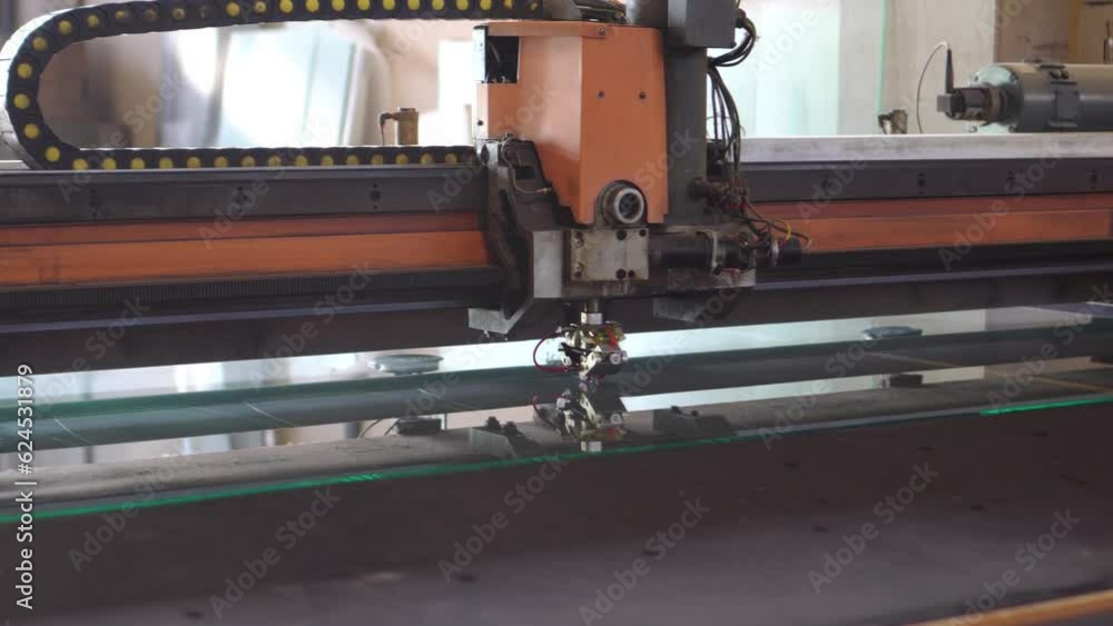 Automatic machinery is cutting the glass Automatic machinery is cutting the glass