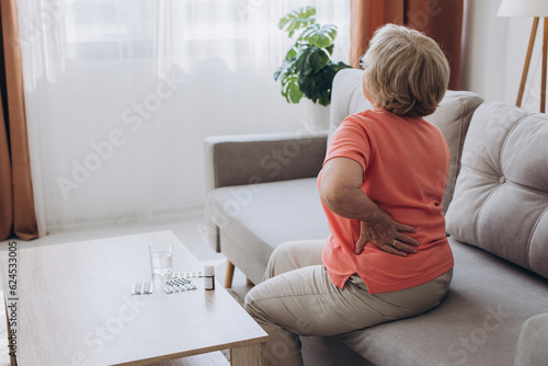 Fototapeta Senior lady feeling muscles pain attack, holding back, having problem with standing up