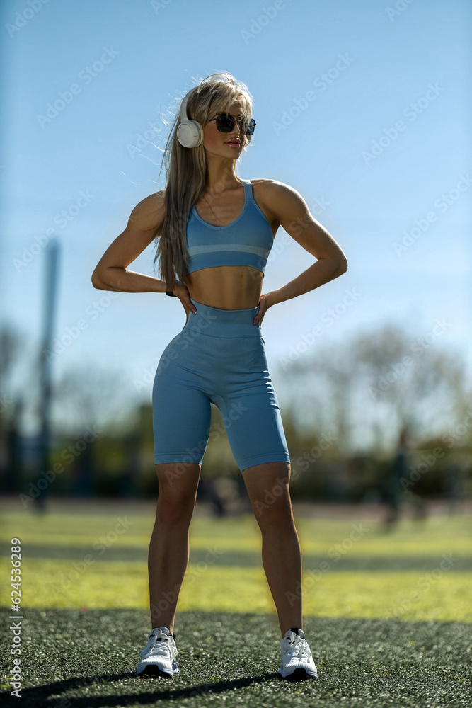 blonde athletic girl stands on the football field blonde athletic girl stands on the football field