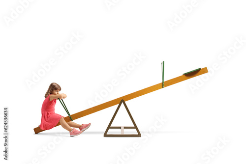 Sad little girl sitting on a seesaw alone