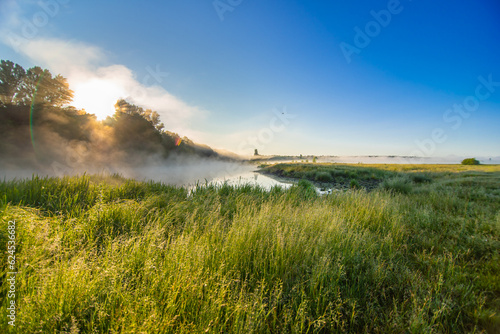 Landscape with fog over the river during sunrise