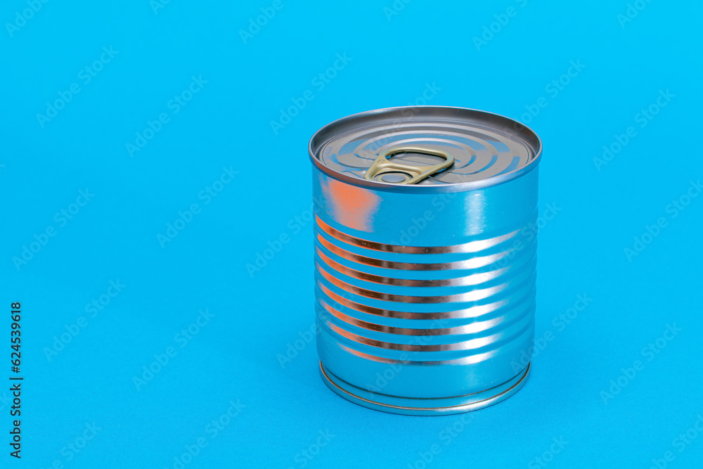 Unopened Tin Can with Blank Edge on Light Blue Background. Canned Food. Aluminum Can for Safe and Long Term Storage of Food. Steel Sealed Food Storage Container