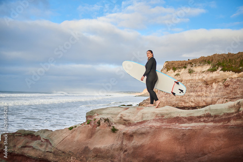 Photography Full length view of the caucasian woman walking with surfboard at the rocky hill
