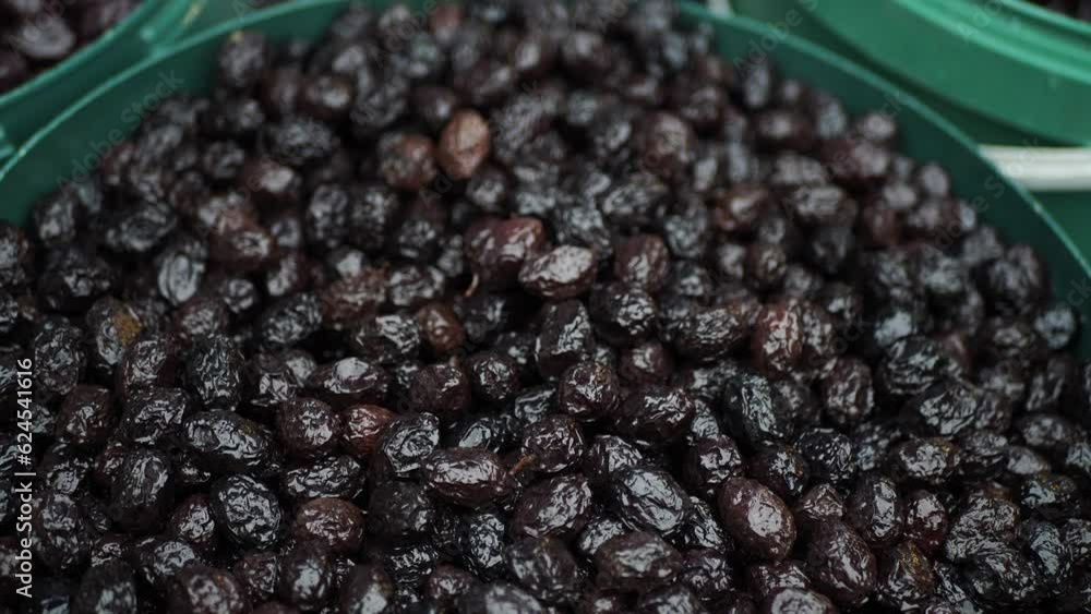 slices black olives with spoon in a bowl , slices black olives with spoon in a bowl ,