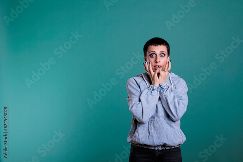 Afraid nervous woman having terrified expression after hearing the news, terrified person standing in studio posing over isolated background. Frightened female looking at camera with shock reaction