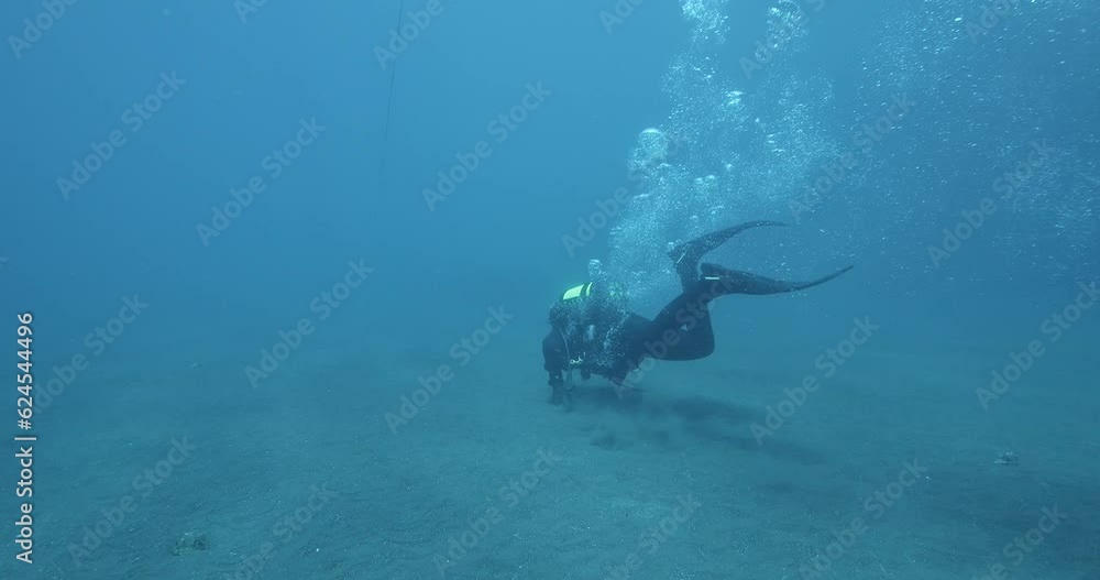 Scuba diver pulling along seabed in heavy current. Scuba diver pulling along seabed in heavy current.