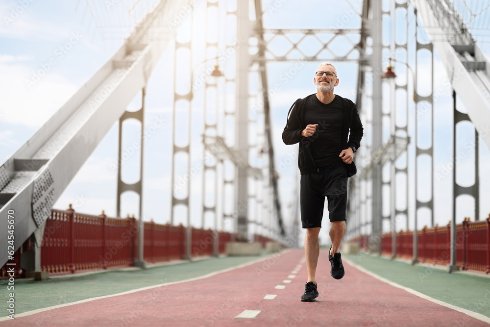 Healthy senior sportsman running by walking bridge in the morning