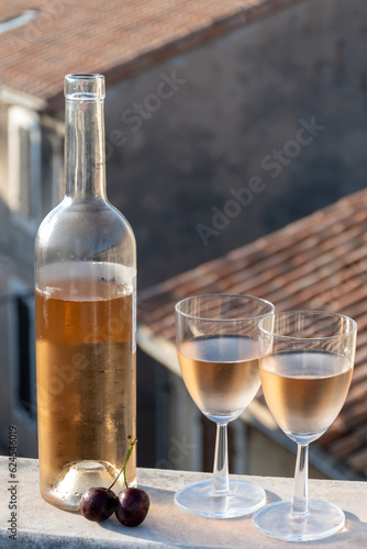 French cold rose dry wine from Provence in two glasses in sunny day with view on old roofs of Arles town
