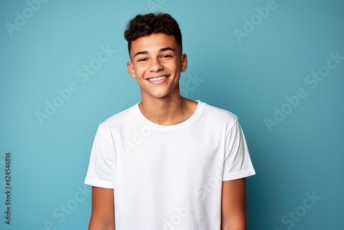 smiling young man in white shirt against blue background, photo