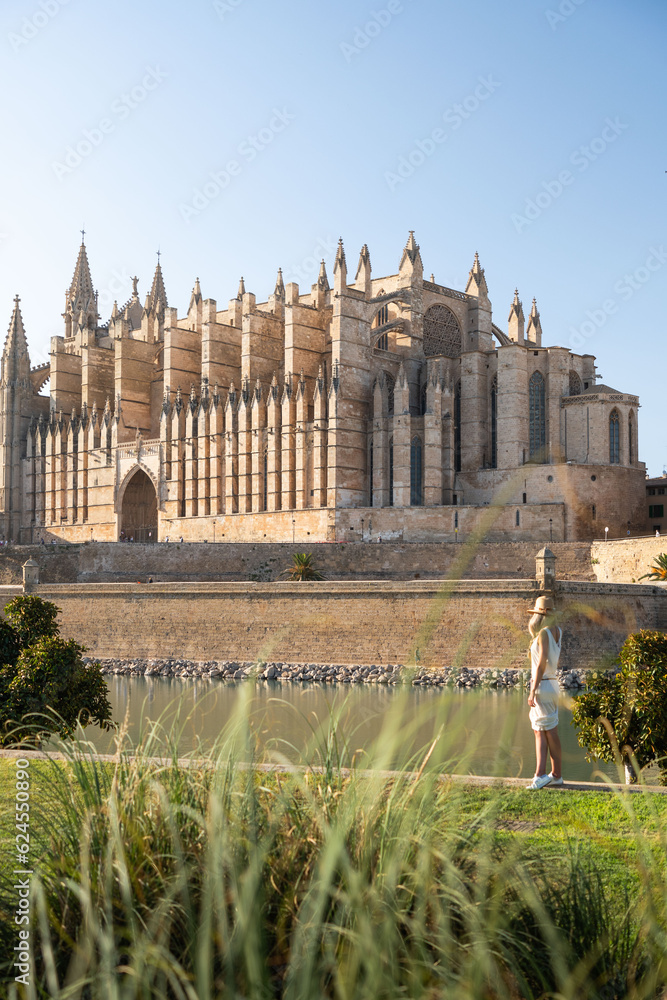 Rear view of blonde woman looking Cathedral La Seu in Palma de Mallorca, Spain