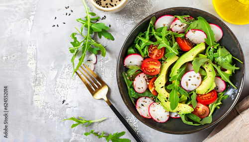Diet menu. Healthy salad of fresh vegetables - tomatoes, avocado, arugula, radish and seeds on a bowl. Vegan food. Flat lay. Banner. Top view