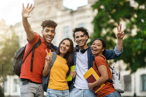 Group Of Cheerful Multietnic College Friends Posing Together Outdoors photo