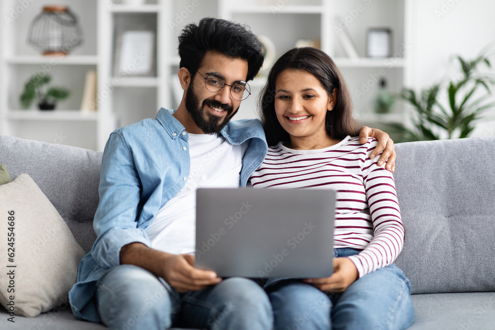 Sweet hindu couple watching movie on laptop at home Sweet hindu couple watching movie on laptop at home