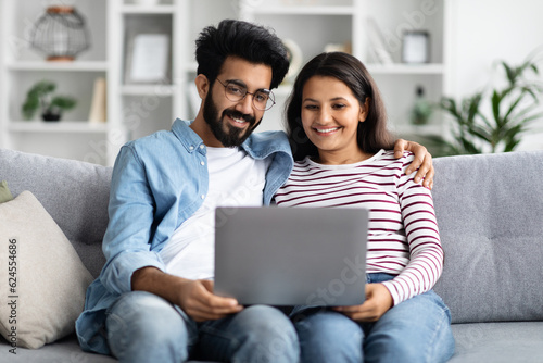 Sweet hindu couple watching movie on laptop at home © Prostock-studio