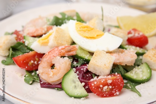 Delicious Caesar salad with shrimps on plate, closeup
