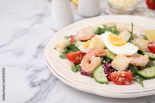 Delicious Caesar salad with shrimps on white marble table, closeup. Space for text