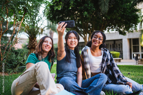 Three university students taking a selfie with a smart phone to share it on social media