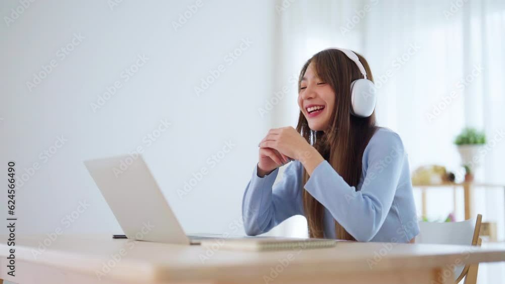 Young asian woman wearing headset working on computer laptop at house. Work at home, Video conference, Video call, Student learning online class, Homeschooling Young asian woman wearing headset working on computer laptop at house. Work at home, Video conference, Video call, Student learning online class, Homeschooling