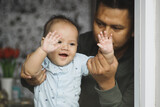 Young loving Asian father playing and spending time with infant child, copy space. Happiness of fatherhood