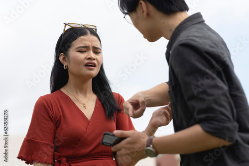 A man confronts his cheating partner over a extramarital relationship with another guy on her phone. Pointing to the cellphone as evidence.