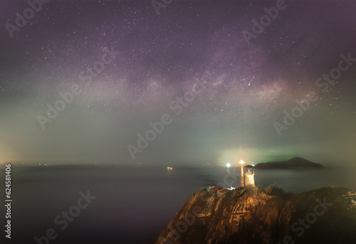 clouds over the sea with milky way and light house