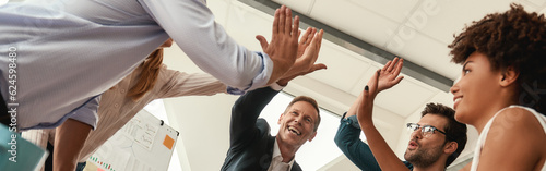 Success Business people giving each other high-five and smiling while working together in the modern office