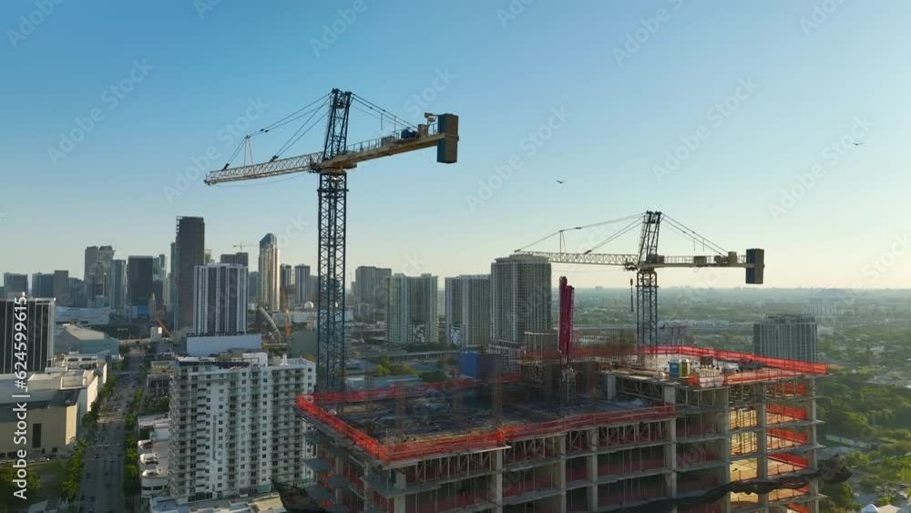 Aerial view of new developing residense in american urban area. Tower cranes at industrial construction site in Miami, Florida. Concept of housing growth in the USA Aerial view of new developing residense in american urban area. Tower cranes at industrial construction site in Miami, Florida. Concept of housing growth in the USA