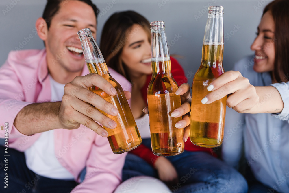 Latin friends drinking beer and watching television at home in Mexico Latin America, hispanic people friendship Latin friends drinking beer and watching television at home in Mexico Latin America, hispanic people friendship