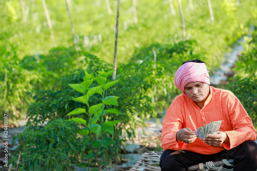 Happy Indian farmer, farmer holding indian rupees in hands, smart farming