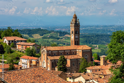 Fotografie Catholic church among houses with red roofs in small italian town