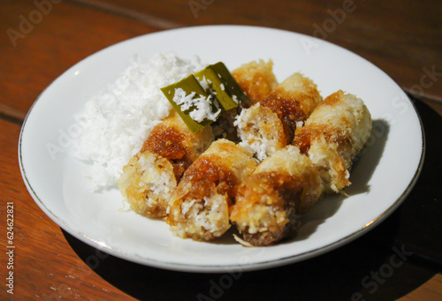 Kue putu, a traditional Indonesian snack made from rice flour filled with palm sugar and grated coconut as topping photo