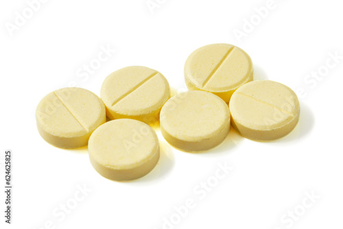 Many Circle-shaped yellow pills isolated on a white background.