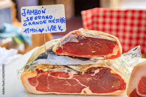 Antibes, France - May 24, 2023: Italian serrano ham, dry cured pork cold cut for sale at a local covered provencal farmers market in the old town